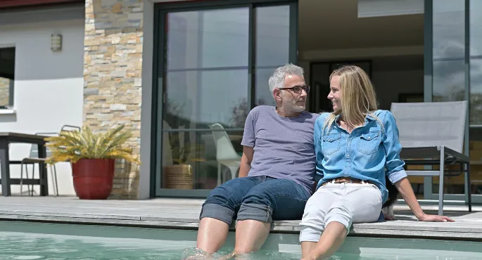 Older couple relaxing by a private pool in Spain after managing taxes with IberianTax