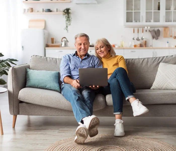 Couple sitting together and filing Spanish non-resident Modelo 210 tax on a laptop