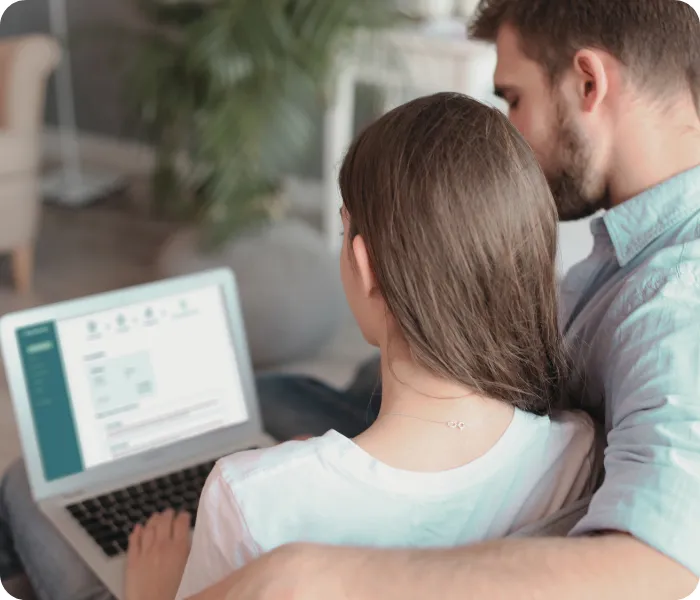 Couple sitting together and filing Spanish non-resident Modelo 210 tax on a laptop